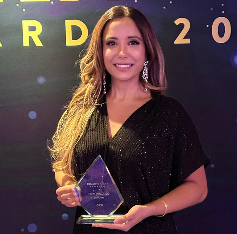 Dr Manrina Rhode holding the Private Dentistry Awards 2023 trophy for Best New Practice London, won by DRMR Clinic